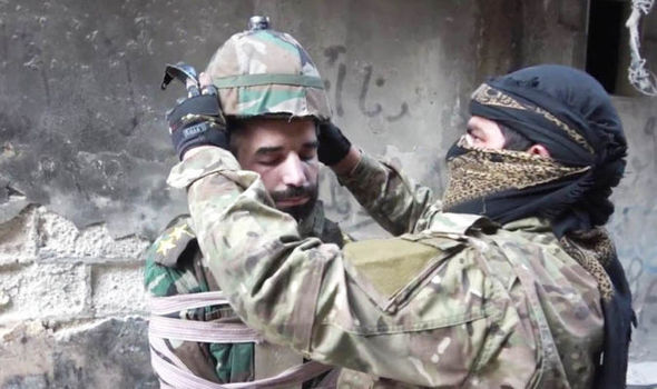 ISIS fitting a bomb helmet to a Syrian solider